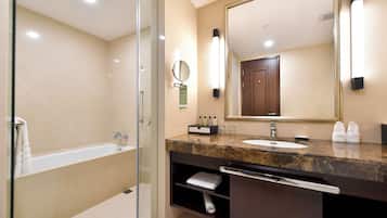 A modern bathroom with a glass shower enclosure, a marble sink vanity, and a large mirror.