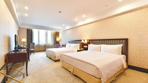 A hotel room with two beds, a desk, a chair, and a lamp. - Evergreen Laurel Hotel Shanghai (Shanghai)
