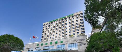 A multi-story hotel with a prominent sign reading "Evergreen Laurel Hotel" and a sign for "Evergreen Laurel Hotel" in a different language.
