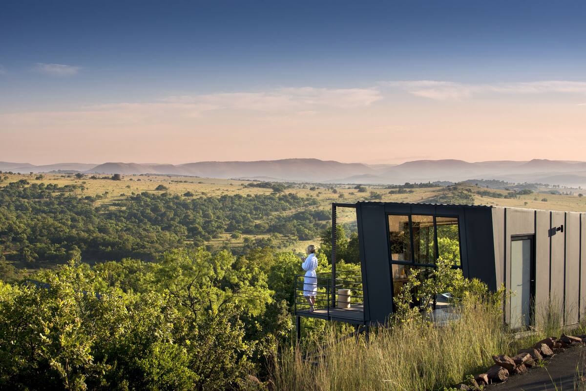 A modern building with a balcony overlooking a lush landscape.
