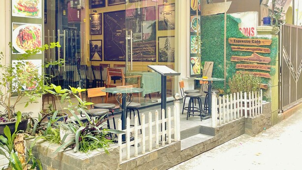 A restaurant with outdoor seating, a signboard with the name 'Amy', and a menu board displaying food items. - Amy Hostel Hue (Hue)
