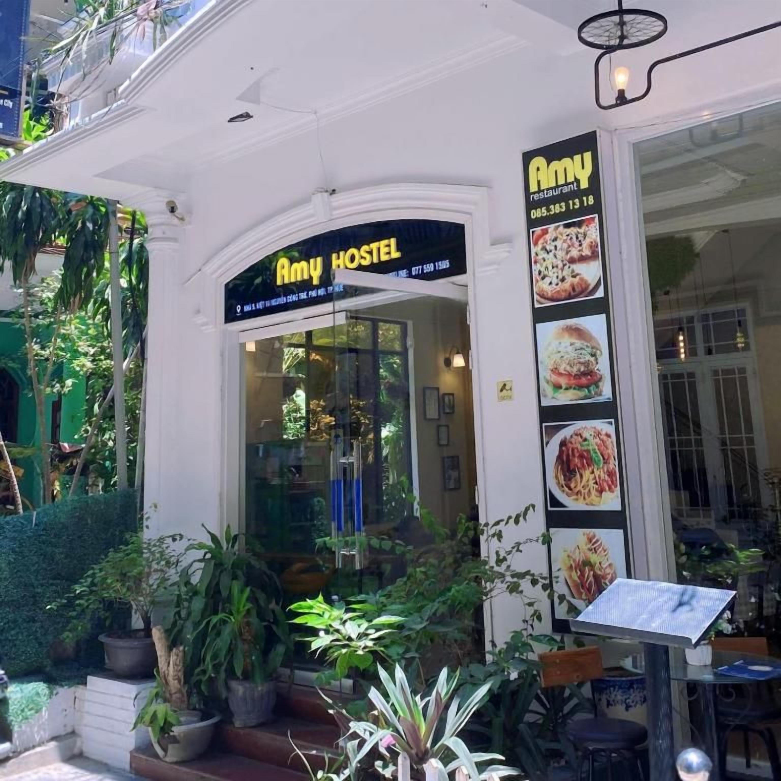Un restaurant appelé «Amy Hostel» avec une enseigne et un menu affiché.
