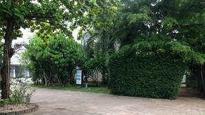 A paved pathway leading to a building with a sign indicating a check-in area. - Natpob Sleep Station Motel (Chiang Rai)