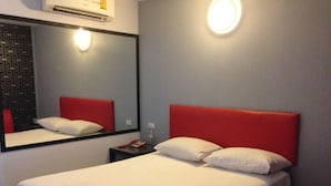 A hotel room with a bed, a nightstand, a mirror, and a wall-mounted light. - Natpob Sleep Station Motel (Chiang Rai)