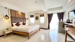 A modern hotel room with a large bed, bedside tables, a desk, and a kitchenette. - My Chiang Mai Boutique Lodge (Chiang Mai)
