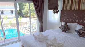 A hotel room with a large bed, a view of a swimming pool, and a balcony with outdoor furniture. - My Chiang Mai Boutique Lodge (Chiang Mai)