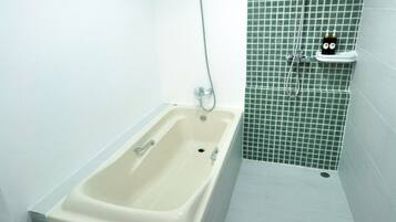 Un baño con bañera, inodoro y ducha.