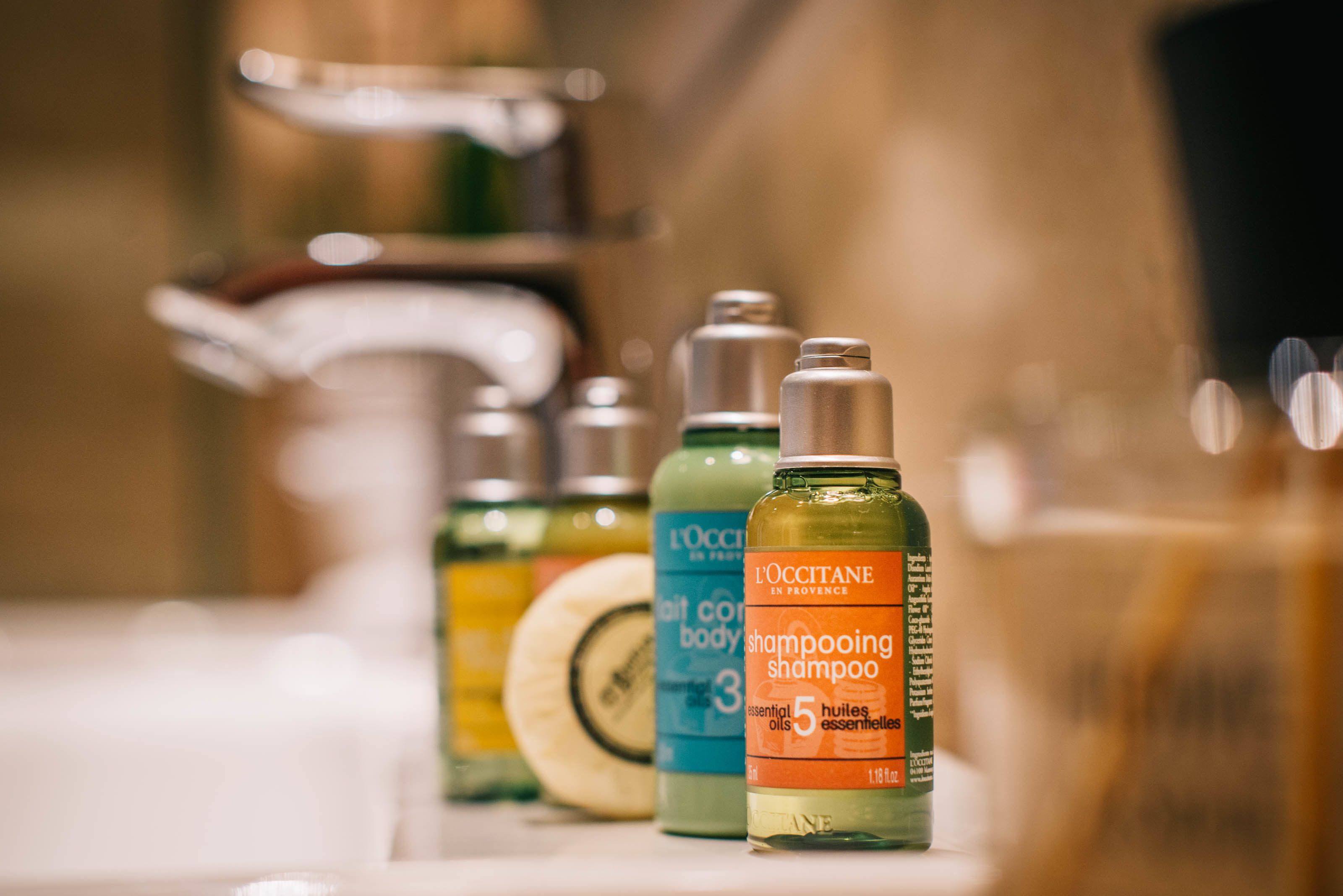 Three bottles of shampoo on a bathroom counter.