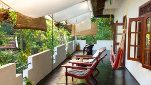 A balcony with a table, chairs, and a hammock. - Jungleside House (Hikkaduwa)