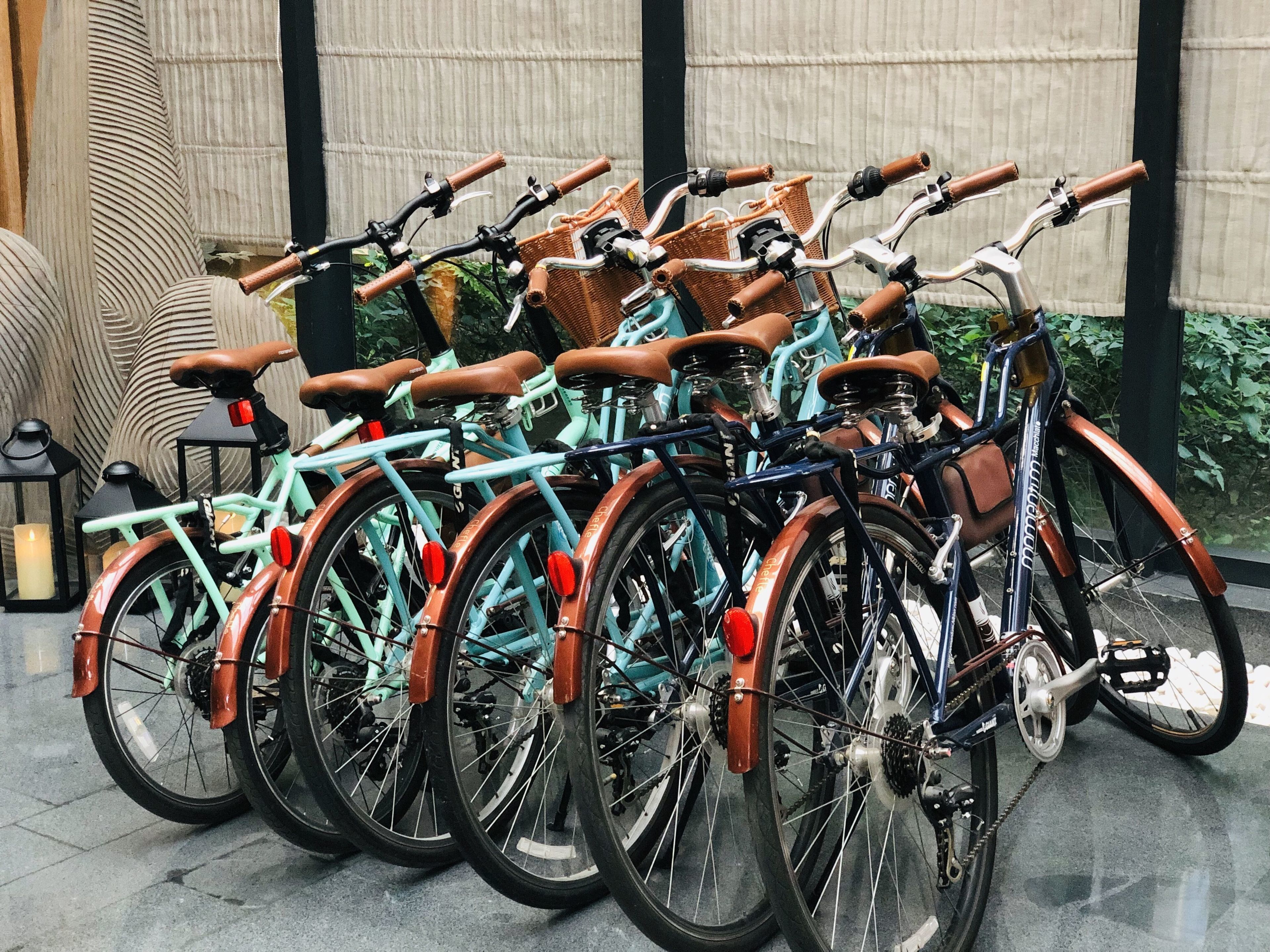 A row of bicycles with baskets, arranged in a row.