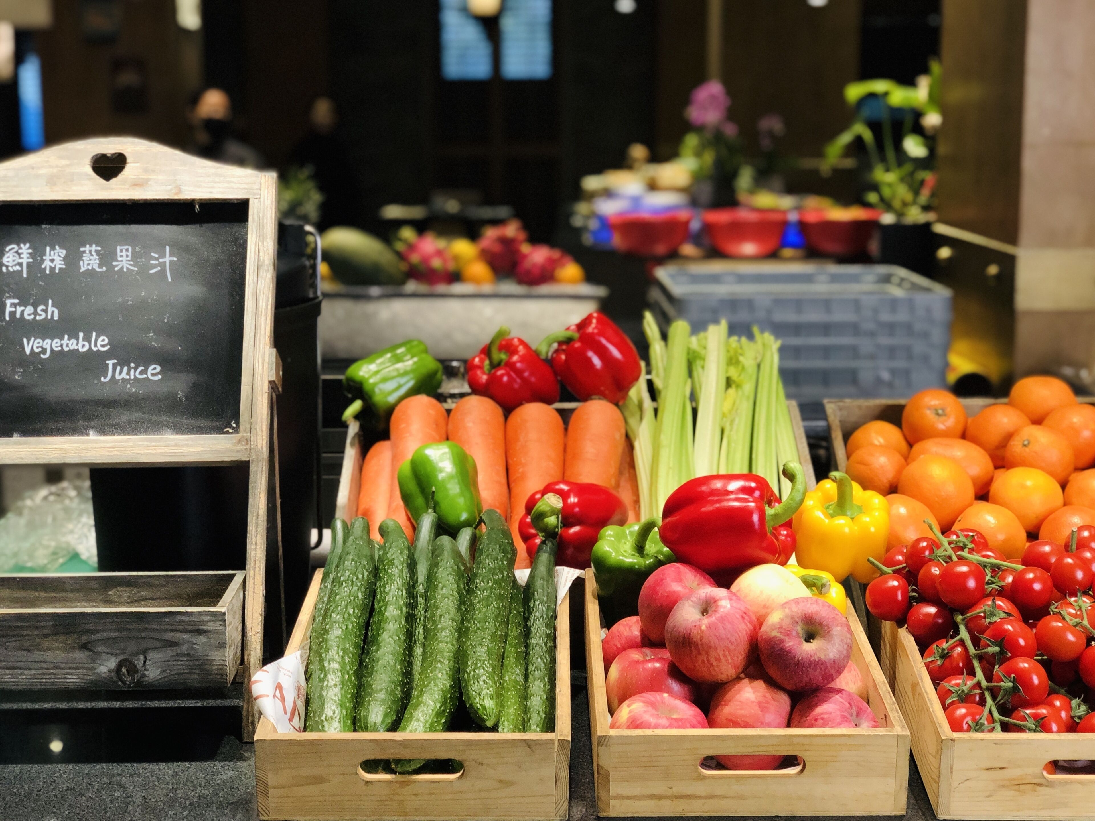 A variety of fresh vegetables and fruits displayed in wooden crates.