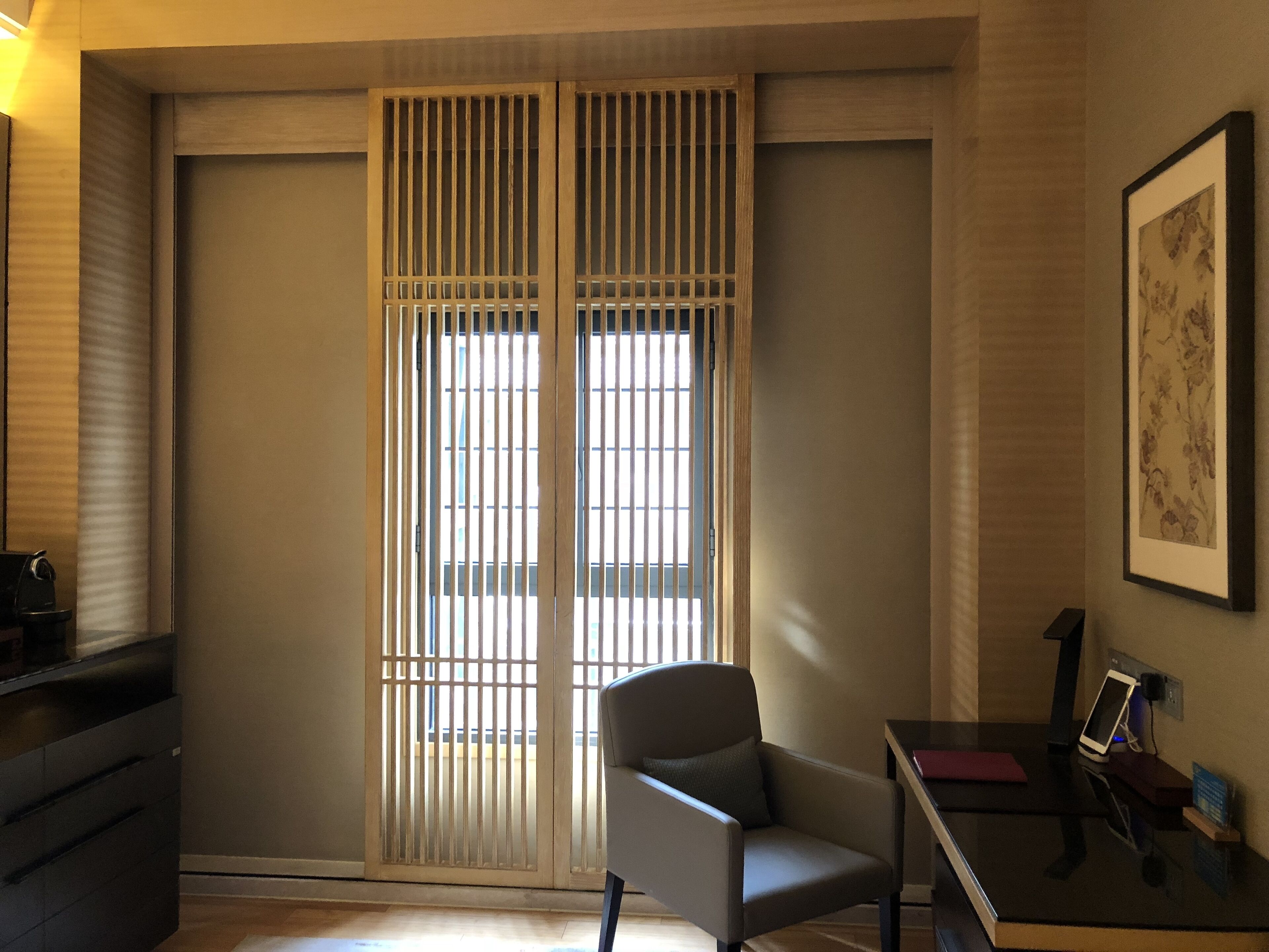 A room with a sliding shoji screen door, a desk with a computer, and a chair.