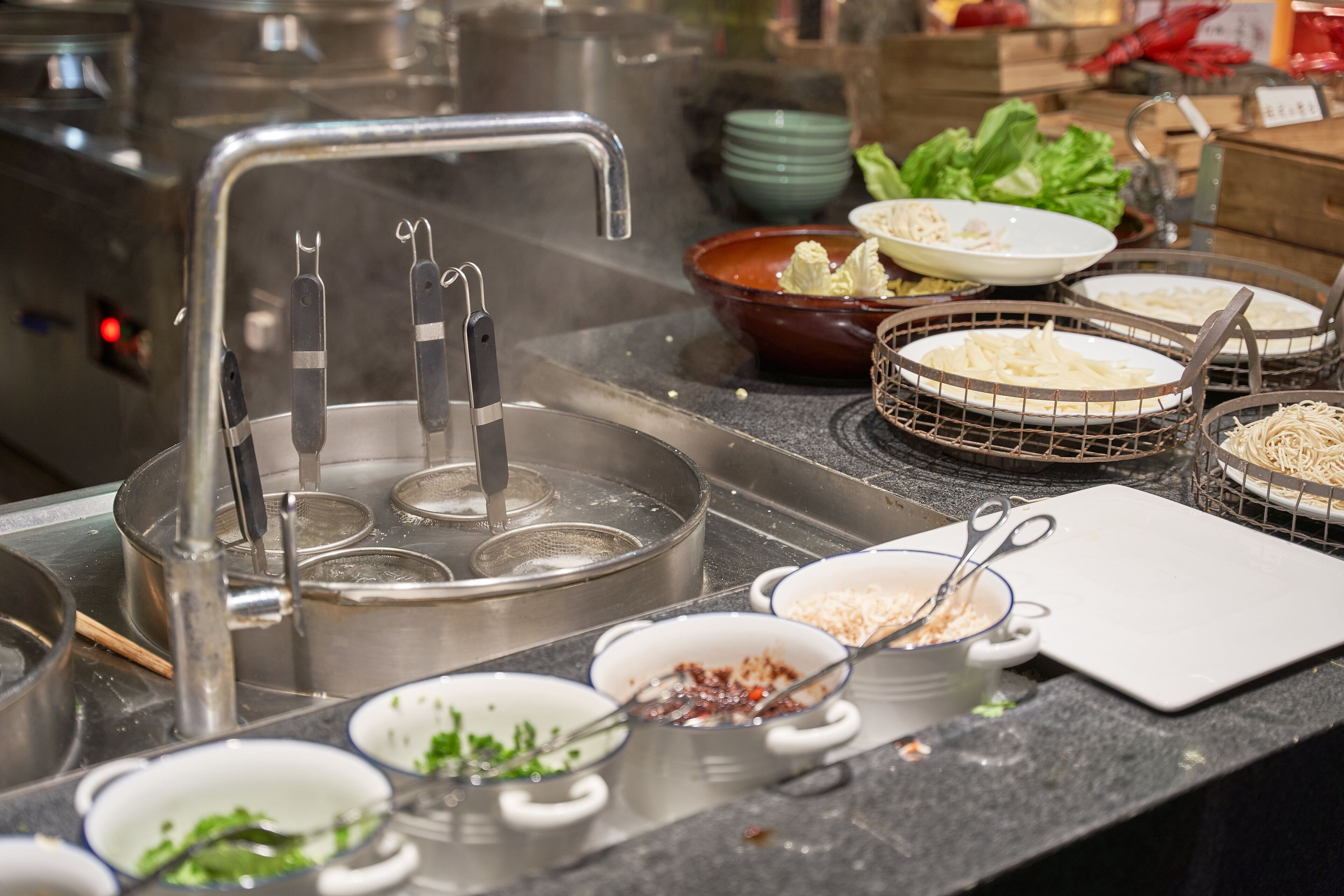 Una encimera de cocina con diversos utensilios, ollas y tazones.