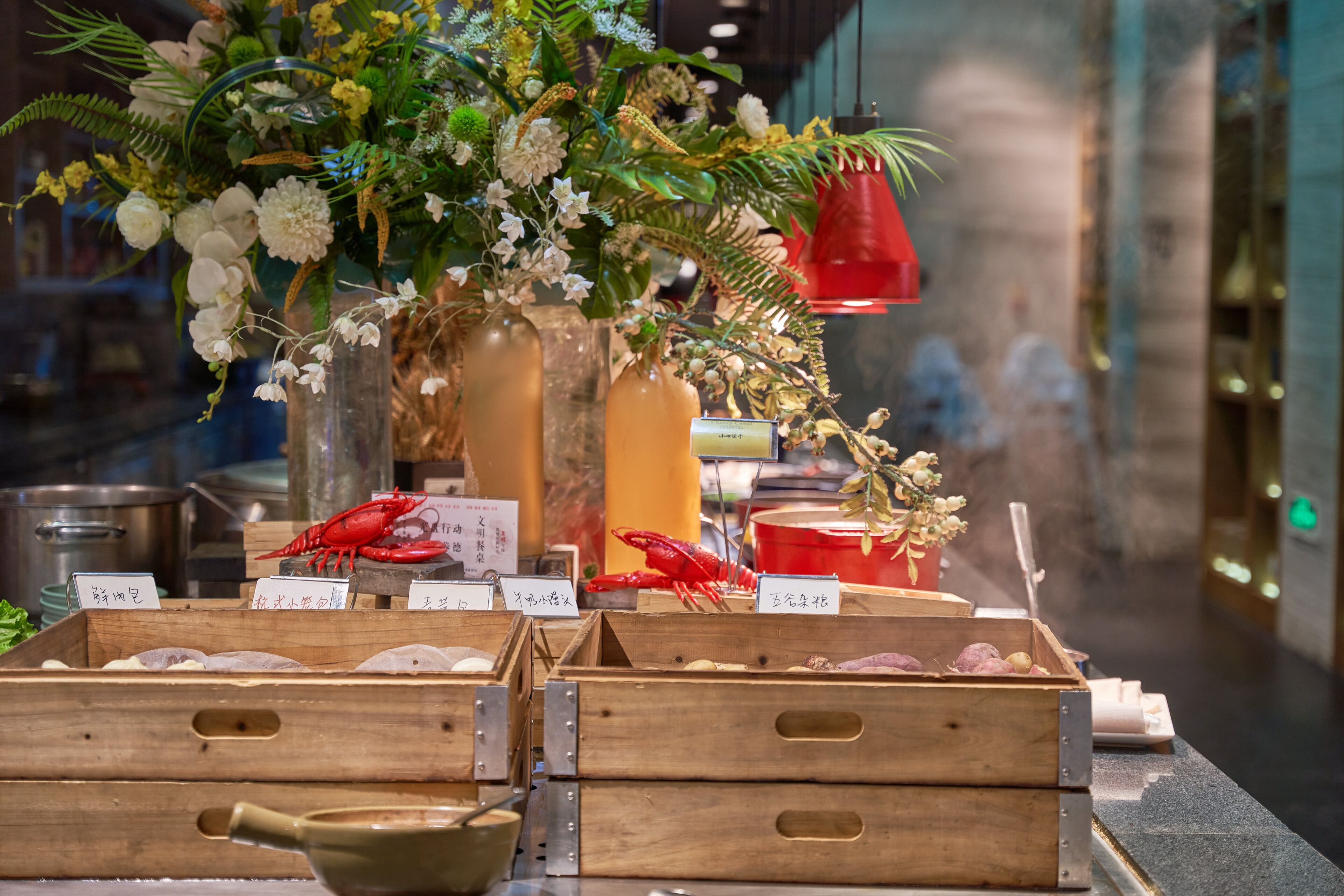 A seafood display with wooden crates, a lobster, and a floral arrangement.