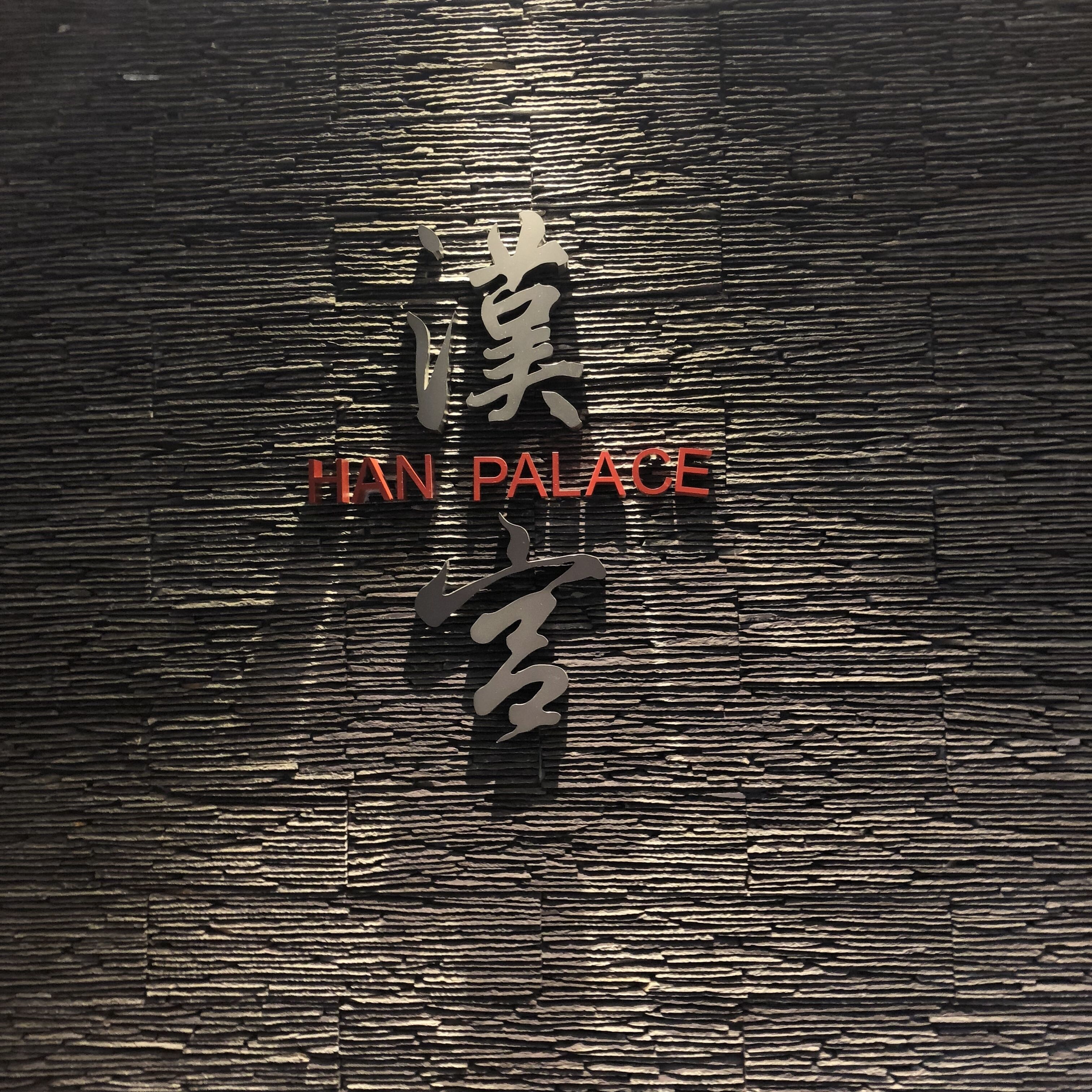 A sign with Chinese characters and the words "HAN PALACE" in red.