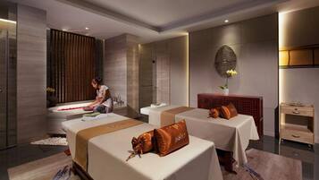 Two single beds with matching headboards and a large mirror create a clean and sophisticated space.