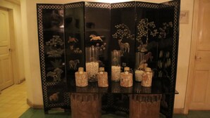 A room with a glass-top table featuring decorative items and a black, ornate cabinet with glass panels. - Roxas President's Inn (Roxas City)