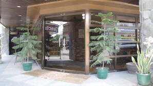 A storefront with glass doors, potted plants, and a sign indicating a parking garage. - Roxas President's Inn (Roxas City)