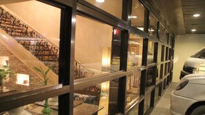 A modern interior with a staircase, a car, and a glass partition. - Roxas President's Inn (Roxas City)
