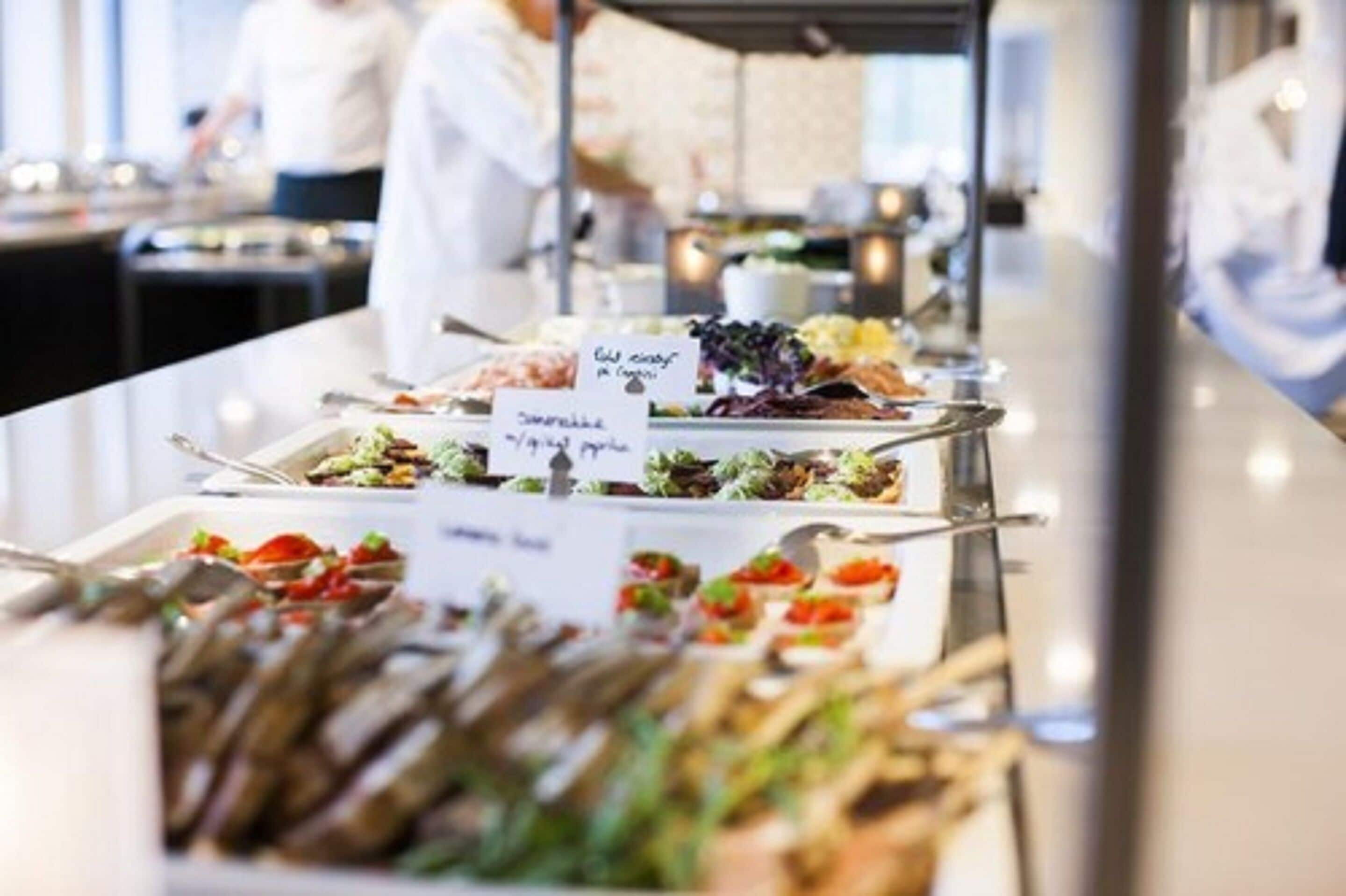 A buffet with various dishes and labels indicating different food options.