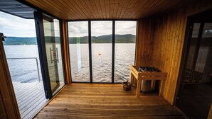 Una terraza de madera con vista a un lago y montañas.