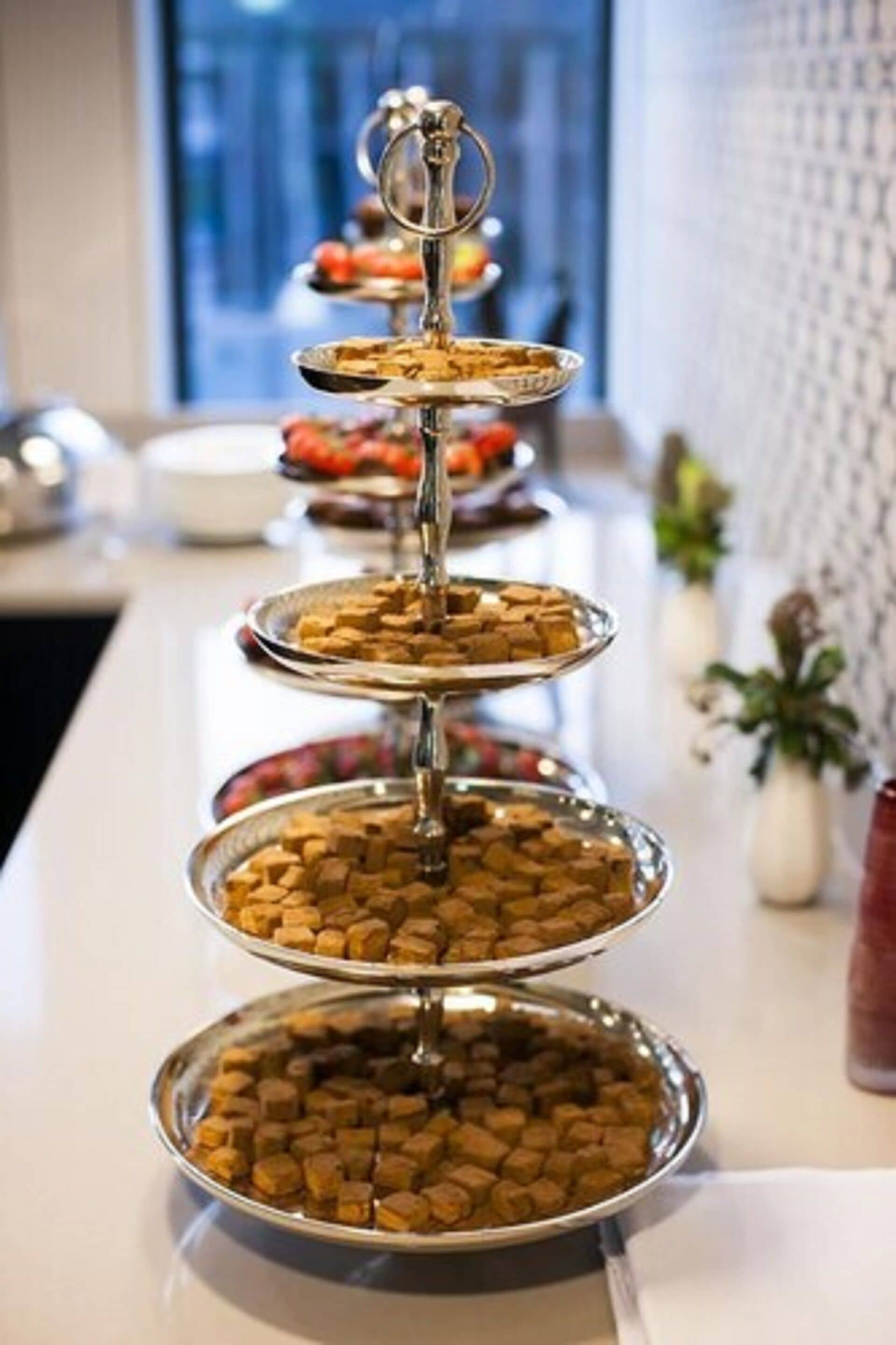 A tiered serving tray with various food items, likely for a buffet or catering event.