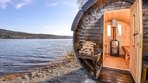 Una cabaña de madera con una fachada circular, una chimenea y un banco en el interior.