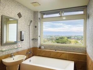 A bathroom with a large window, a sink, and a bathtub. - Waterbirds Family (Toucheng)
