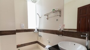 Un baño moderno con un lavamanos blanco, una ducha y un inodoro.