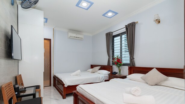 Una habitación de hotel con dos camas, televisión, escritorio y una silla.