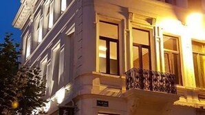 Een meerlaags gebouw met een balkon en een bord waarop staat 