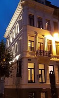 Un edificio de varios pisos con un balcón y un letrero que dice "Goaziya Anduze".