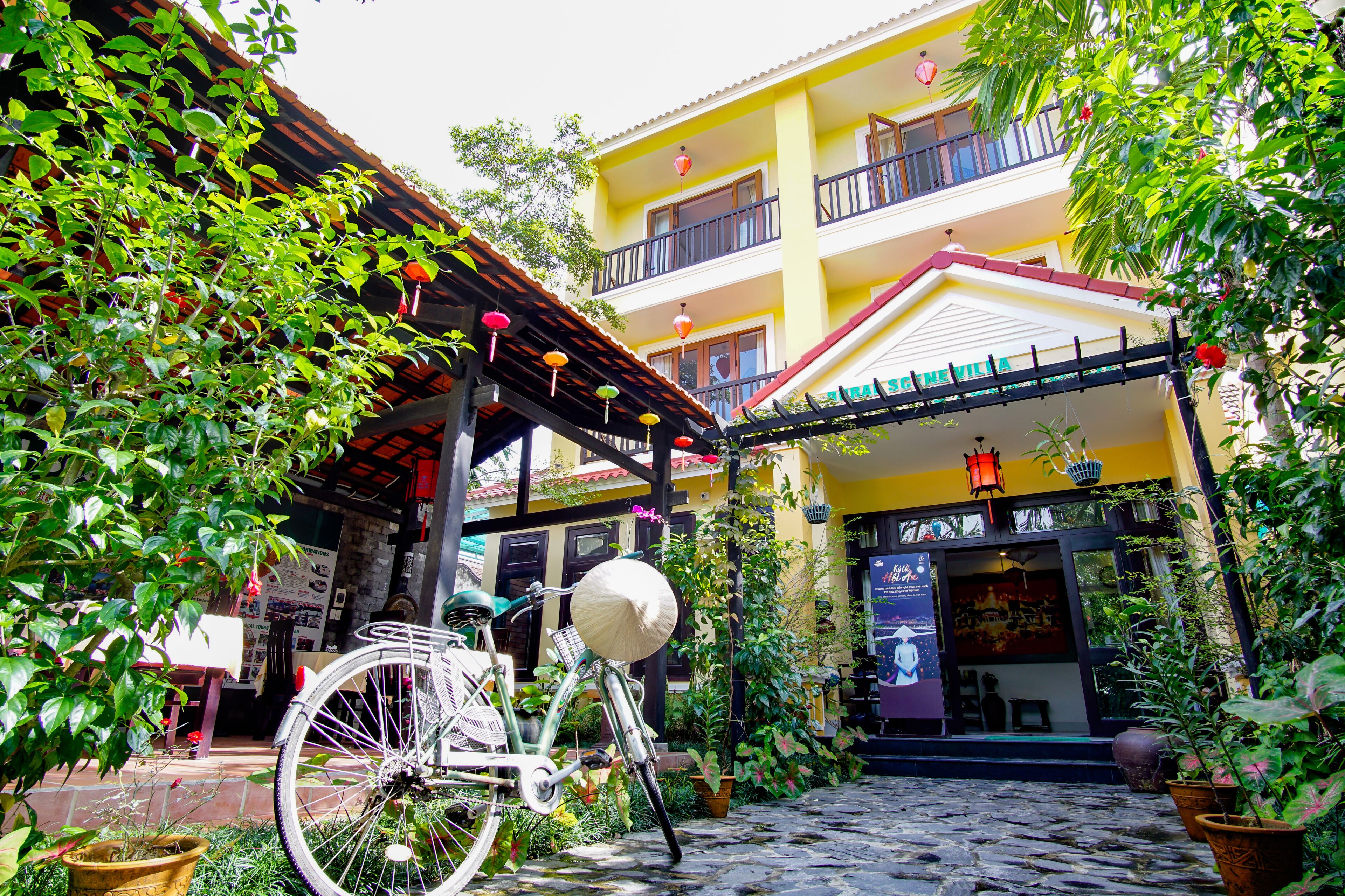 A courtyard with a bicycle, potted plants, and a building with balconies.
