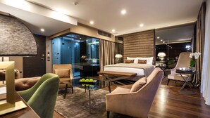 A modern hotel room with a large bed, a glass partition, a seating area with chairs, and a dining table. - SAINT TEN Hotel, Small Luxury Hotels (Belgrade)