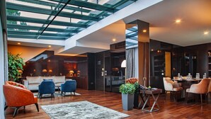 A modern interior with a high ceiling, wooden flooring, and a seating area with sofas and chairs. - SAINT TEN Hotel, Small Luxury Hotels (Belgrade)