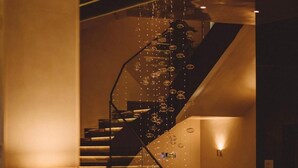A modern staircase with a spiral design, illuminated by ambient lighting and decorative elements. - SAINT TEN Hotel, Small Luxury Hotels (Belgrade)