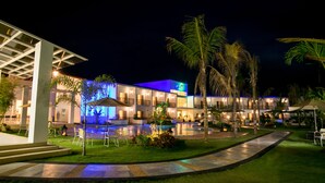 A hotel with a swimming pool, outdoor seating, and palm trees. - Gabi Resort & Spa (Cordova)