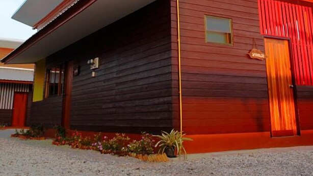 A modern building with a sloped roof and a prominent entrance. - Kanmanee Inn (Chiang Rai)