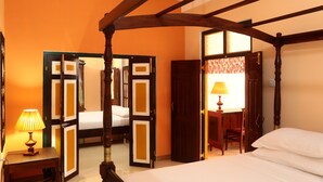A room with a bed, a desk with a lamp, and a door leading to another room. - Villa Ceylon (Kimbulapitiya- Katunayake)