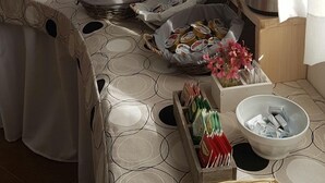 A breakfast buffet with pastries, bread, and beverages on a table with a patterned tablecloth. - Argeste Club Vacanze (Vieste)