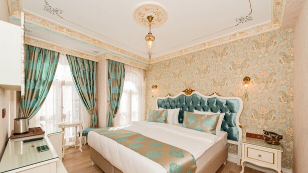 Une chambre d’hôtel avec un grand lit, une table de chevet, une petite table et une chaise.
