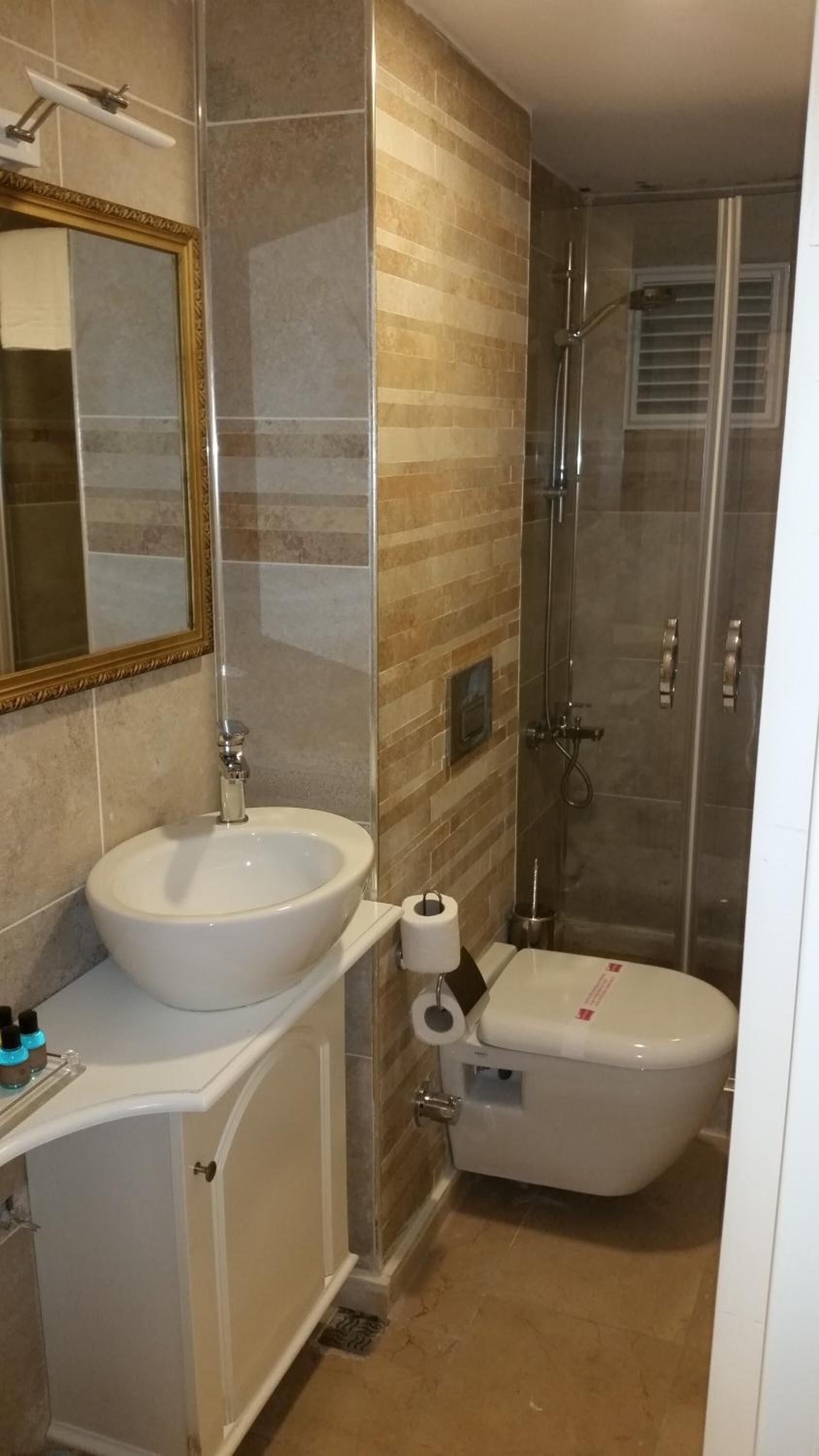 Un baño con lavamanos blanco, inodoro y ducha.