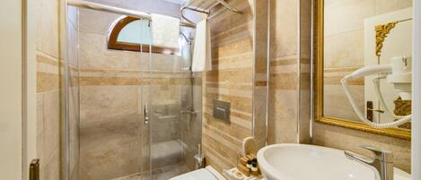 Une salle de bain avec une douche à parois de verre, un lavabo blanc et un miroir de coiffeuse.