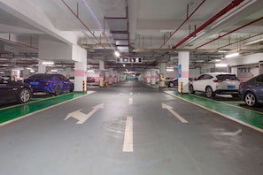 A multi-level parking garage with clear directional arrows on the floor, multiple parking spaces, and a central exit. - Hisoar Hotel Shenzhen (Shenzhen)