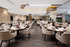 A spacious dining area with multiple tables and chairs, a central column, and a modern ceiling design. - Hisoar Hotel Shenzhen (Shenzhen)