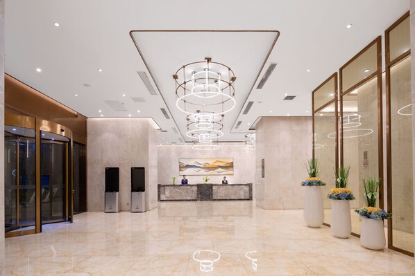 A spacious lobby with a marble floor, a reception desk, and a modern chandelier. - Hisoar Hotel Shenzhen (Shenzhen)