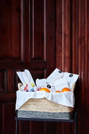 A wicker basket filled with oranges and paper bags on a metal stand against a wooden door. - 60 Balconies Design (Madrid)