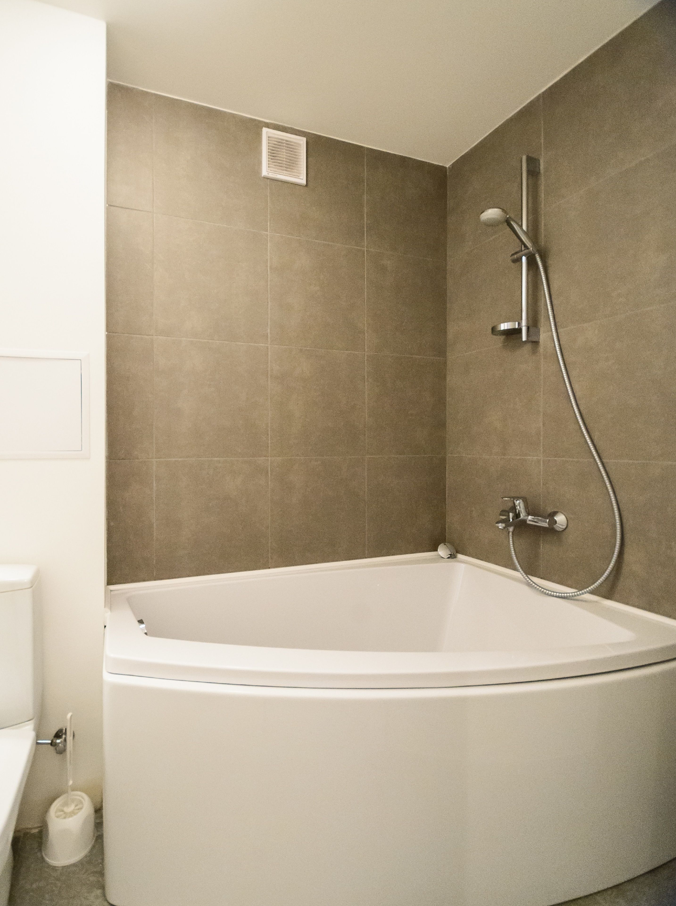 Une salle de bain moderne avec une baignoire sur pieds, une douche et des toilettes.