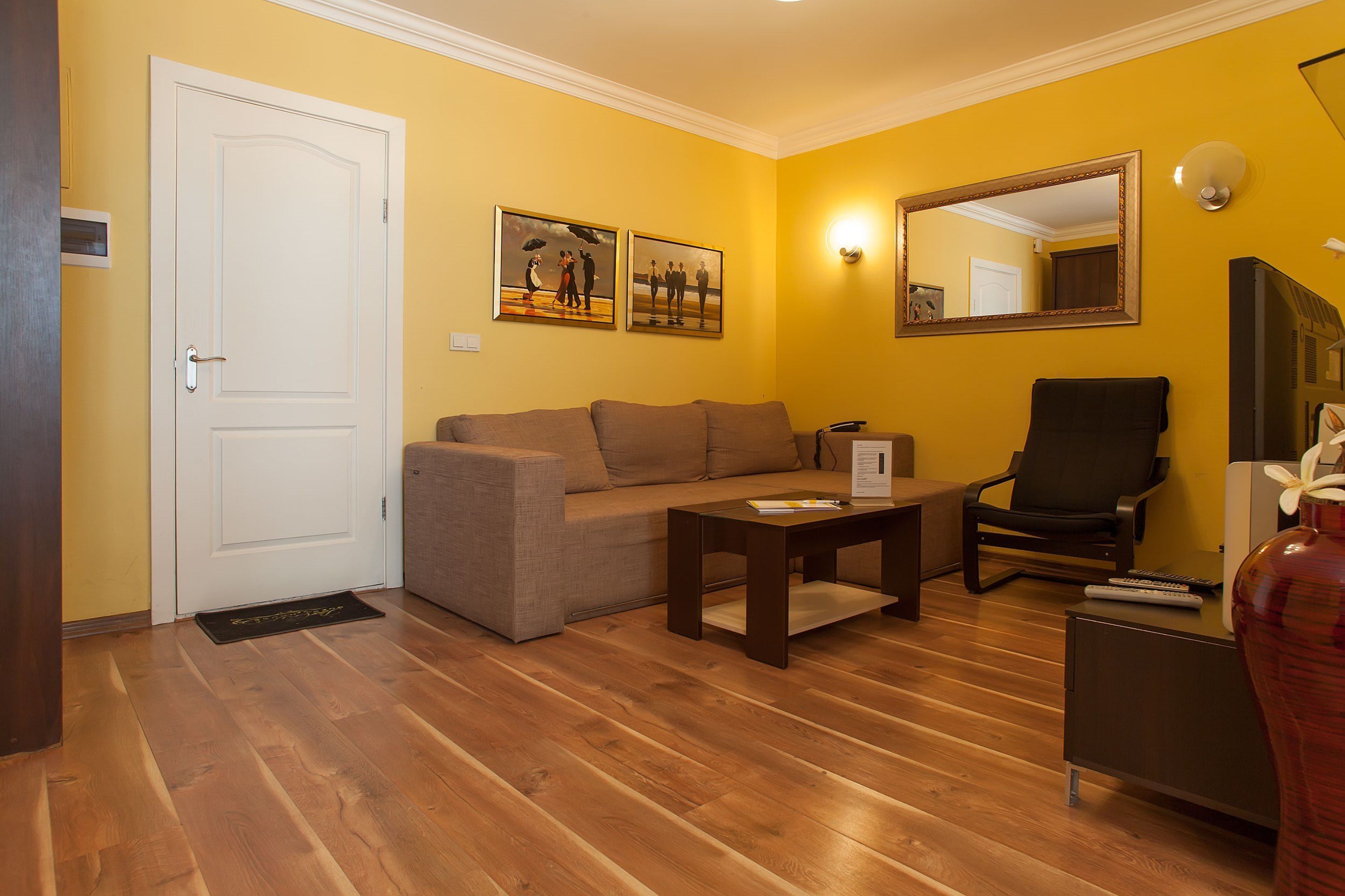Een woonkamer met een bank, een salontafel, een stoel en een televisie.