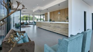 A modern interior with a central kitchen area, seating arrangements, and a large window providing natural light.